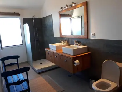 a bathroom with two sinks and a mirror and a shower at Au petit Madère in Prazeres