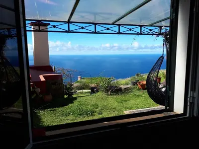 a view of the ocean from a window at Au petit Madère in Prazeres