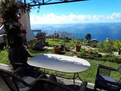 a table and chairs with a view of the ocean at Au petit Madère in Prazeres