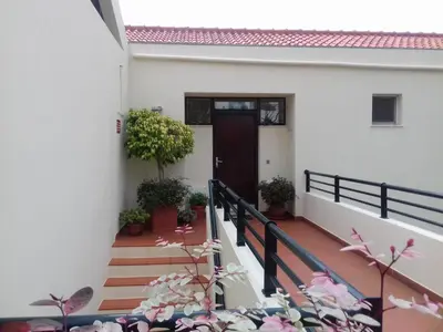 a house with stairs and a door and potted plants at Apartamento do Sol in Arco da Calheta