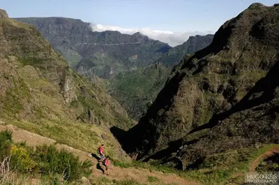 two people walking on a mountain overlooking a valley at Apartamento do Sol in Arco da Calheta
