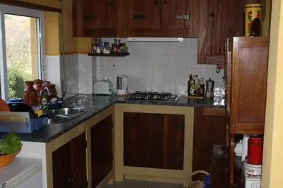 a kitchen with a sink and a stove top oven at Hostel on the Hill in Raposeira