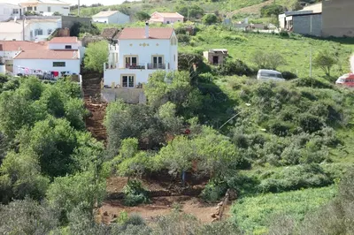 a white house sitting on top of a hill at Hostel on the Hill in Raposeira