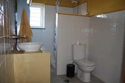 a bathroom with a toilet and a sink at Hostel on the Hill in Raposeira