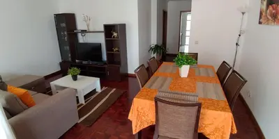 a living room with a table and a couch at Jardins Piornais Funchal Apartment in Funchal