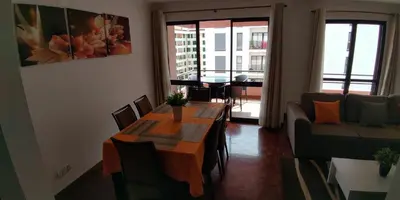 a living room with a table and a couch at Jardins Piornais Funchal Apartment in Funchal