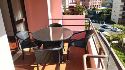 a patio table and chairs on a balcony at Jardins Piornais Funchal Apartment in Funchal