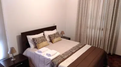 a bedroom with a large bed with two pillows at Jardins Piornais Funchal Apartment in Funchal