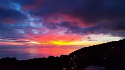 a table and chairs on a balcony with a view of the ocean at Vista Romantica Madeira in Arco da Calheta