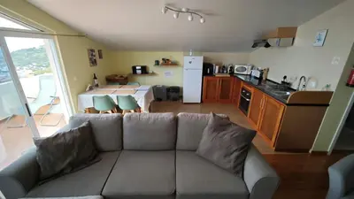 a living room with a couch and a kitchen at Vista Romantica Madeira in Arco da Calheta