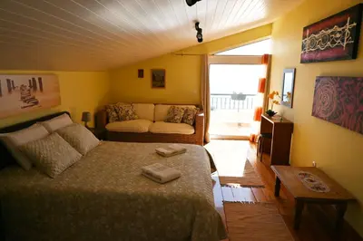 a bedroom with a bed and a couch in it at Vista Romantica Madeira in Arco da Calheta