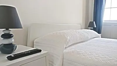 a bedroom with a bed with a lamp and a remote control at Museum House in Funchal