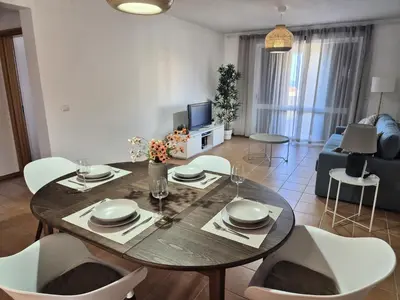 a living room with a dining table and chairs at Cantinho do Porto Santo in Porto Santo