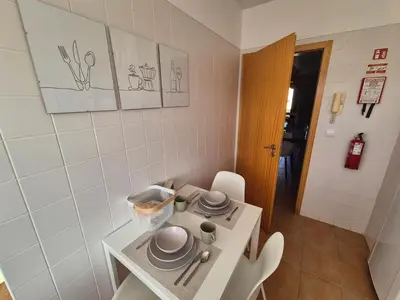 a small kitchen with a table with dishes on it at Cantinho do Porto Santo in Porto Santo