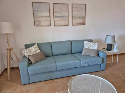 a blue couch in a living room with pillows on it at Cantinho do Porto Santo in Porto Santo