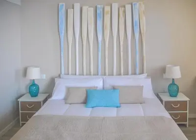 a bedroom with a large white bed with blue pillows at Apartamentos do Mar in Funchal