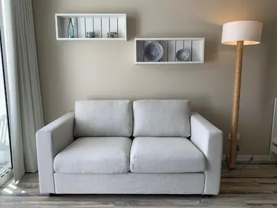 a living room with a couch and a sliding glass door at Apartamentos do Mar in Funchal