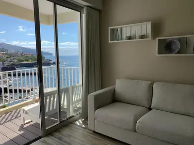 a view of a building with the ocean in the background at Apartamentos do Mar in Funchal