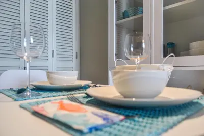 a table with two wine glasses and plates on it at Apartamentos do Mar in Funchal
