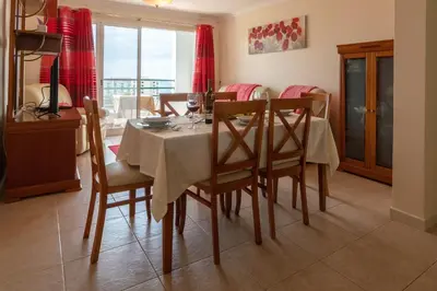 a dining room with a table and chairs and a window at Apartamento Rodrigues in Funchal