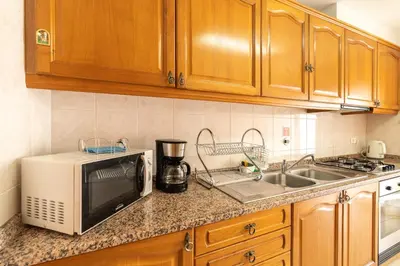 a kitchen with a microwave and a sink at Apartamento Rodrigues in Funchal