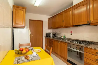 a kitchen with a yellow table with fruit on it at Apartamento Rodrigues in Funchal