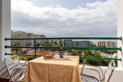 a table with a bottle of wine on a balcony at Apartamento Rodrigues in Funchal