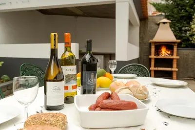 a table with bottles of wine and a plate of food at Charming Apartments in Funchal - São Gonçalo in Funchal