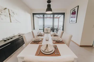 a dining room with a white table and chairs at Ocean View Villa in Funchal