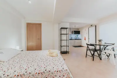 a white bedroom with a bed and a table at Ocean View Villa in Funchal