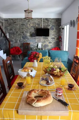 a table with bread and fruit on a table at Quinta Terezinha in Ribeira Brava