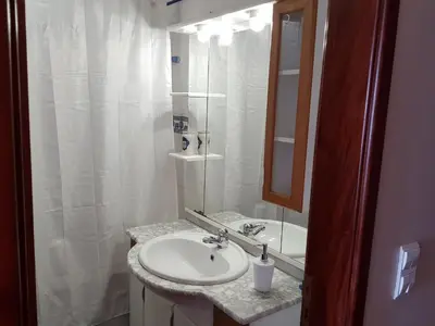 a white bathroom with a sink and a mirror at Vila Régia in Funchal