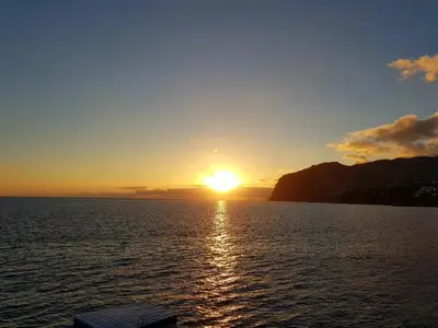 a sunset from a boat in the water at Vila Régia in Funchal