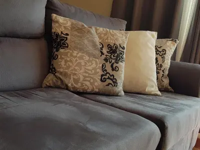 a couch with four pillows on it at Vila Régia in Funchal
