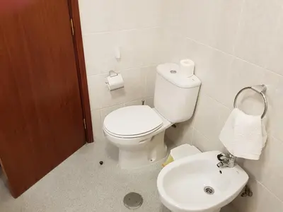 a bathroom with a white toilet and a sink at Vila Régia in Funchal