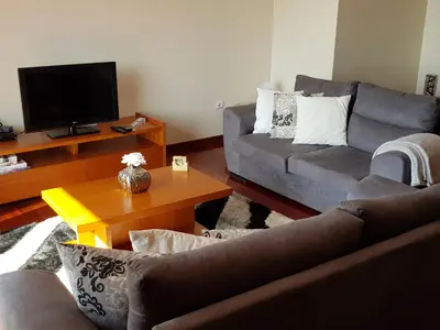 a living room with two couches and a tv at Vila Régia in Funchal