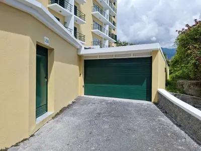 a green garage door on the side of a building at Vila Régia in Funchal