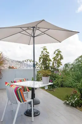 a table and chairs with an umbrella on a patio at Belvedere Boutique - Adults only in Funchal