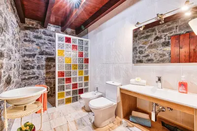 a kitchen with a stove and a stone wall at Seixal Sunny Villa A & B by Amazing Madeira in Seixal