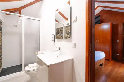 a living room with stone walls and wicker chairs at Seixal Sunny Villa A & B by Amazing Madeira in Seixal