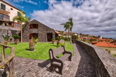 a bench sitting on a brick walkway next to a building at Seixal Sunny Villa A & B by Amazing Madeira in Seixal