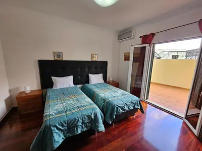 a bedroom with a bed with a green comforter at Apartment Bonimar in Funchal