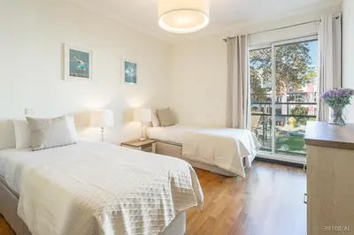 a white bedroom with two beds and a window at Rodamar I by An Island Apart in Funchal