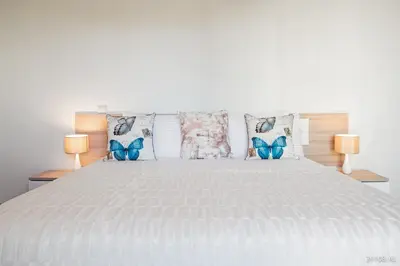 a bedroom with a white bed with two lamps at Rodamar I by An Island Apart in Funchal