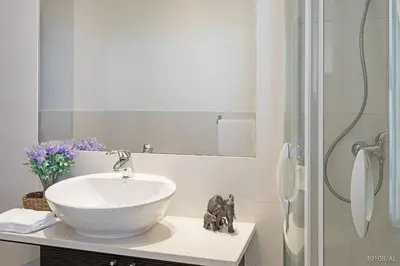 a bathroom with a white sink and a shower at Rodamar I by An Island Apart in Funchal