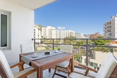 a balcony with a wooden table and chairs at Rodamar I by An Island Apart in Funchal