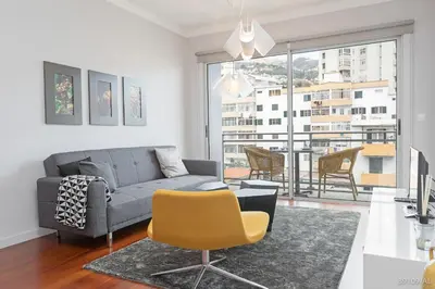 a living room with a couch and a table and chairs at Santa Catarina l by An Island Apart in Funchal
