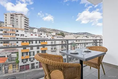 a table and chairs on a balcony with a view at Santa Catarina l by An Island Apart in Funchal