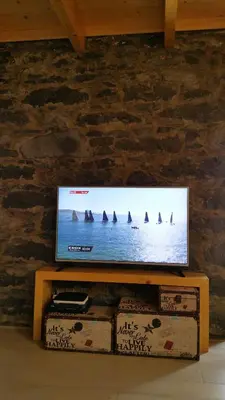 a flat screen tv sitting on top of a wooden table at Estrela do Mar - Alojamento Local in Calheta