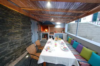 a dining room with a table and chairs and a fireplace at Estrela do Mar - Alojamento Local in Calheta